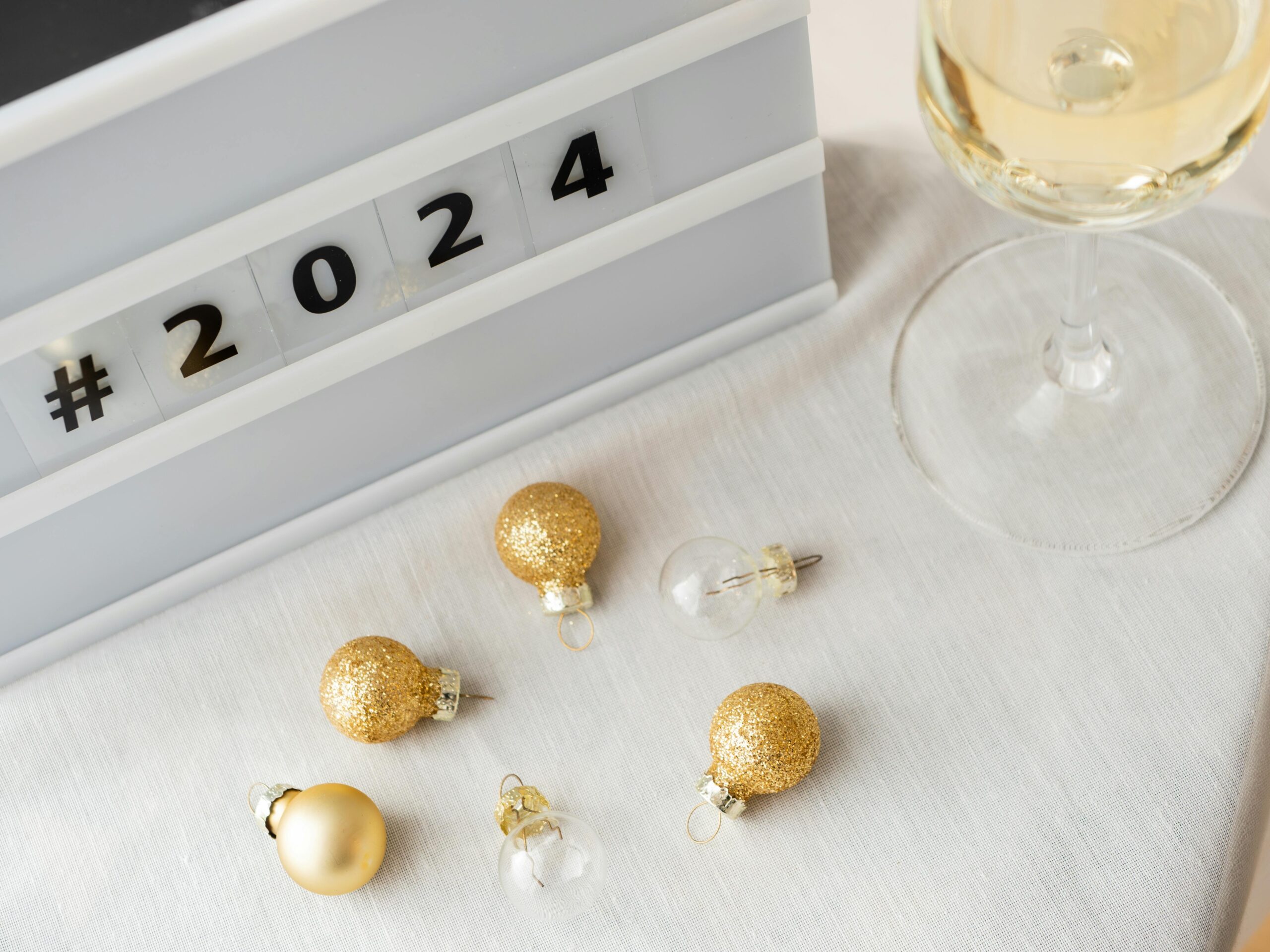 Festive New Year 2024 setup with champagne and golden decorations.